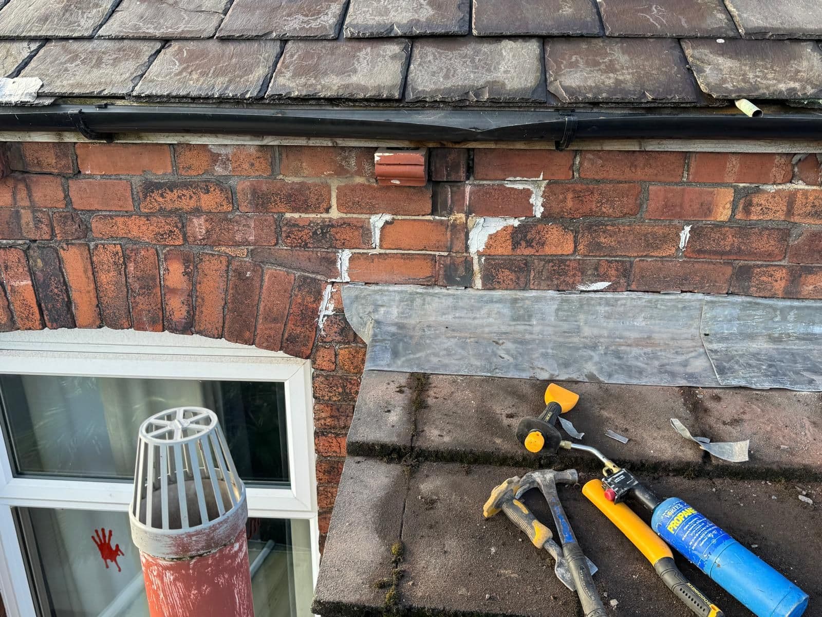 Full view: Weathered chimney vs. completed restoration — before